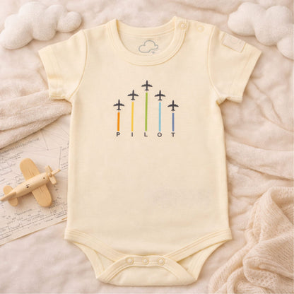 Beige short sleeve baby bodysuit with ARROWS graphic, lifestyle view – Kumy Kids